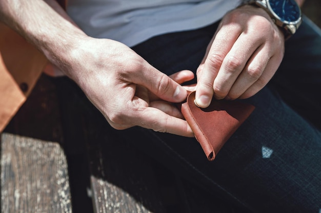 Porta-moedas de couro em closeup de mãos masculinas