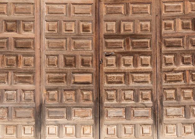 Porta velha de madeira com uma pequena fechadura e uma maçaneta de ferro