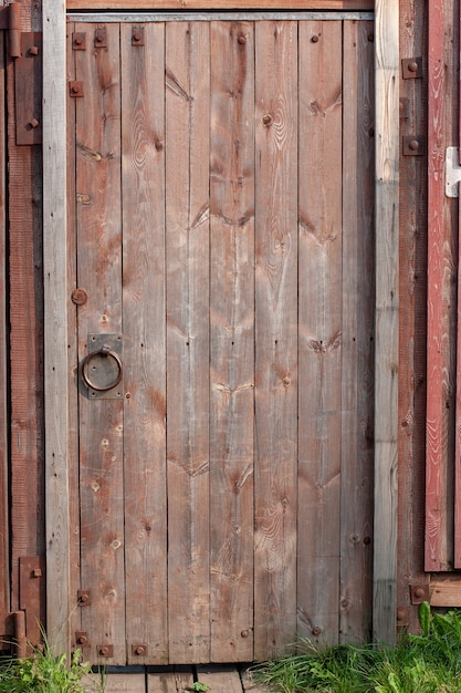 Porta velha de madeira vermelha na cerca