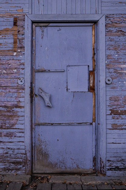 Porta velha de madeira vintage fechada, roxa com pintura descascada