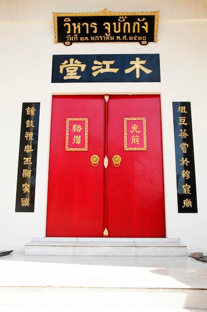 Porta vermelha antigo estilo chinês clássico sobre fundo de parede branca de Wat Wachirathammasatit ou templo wat thung satit