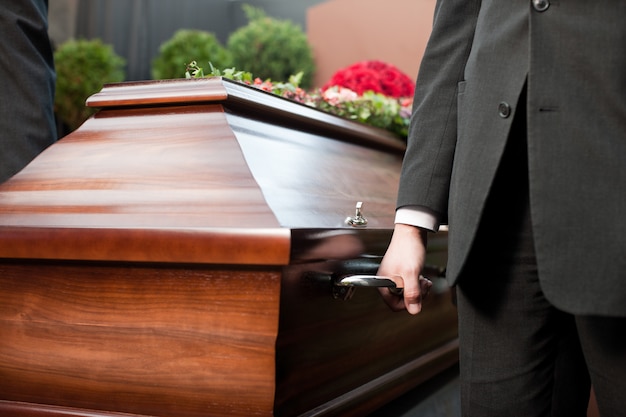 Foto portador de ataúd llevando ataúd en el funeral