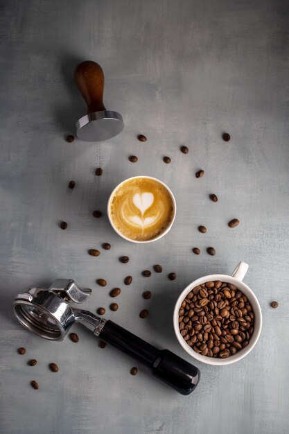 Foto portafiltro con café con leche y granos de caféformato vertical