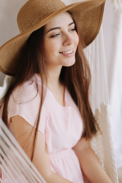 Portait de una joven y bella mujer sonriente con sombrero de verano