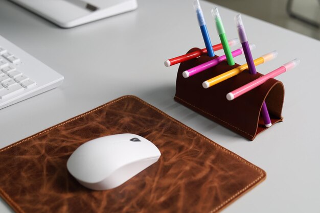 Portalápices de cuero con lápices de colores aislado en el escritorio de la oficina
