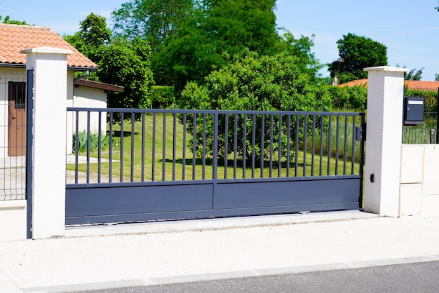 Portão doméstico de metal cinza clássico na entrada do jardim da casa