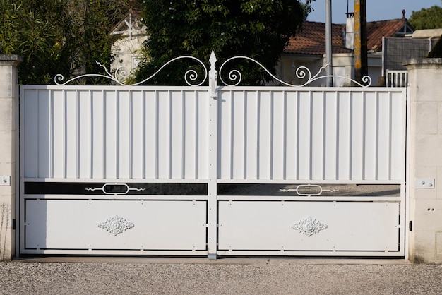 Portão doméstico de metal clássico branco na entrada do jardim do portal da casa