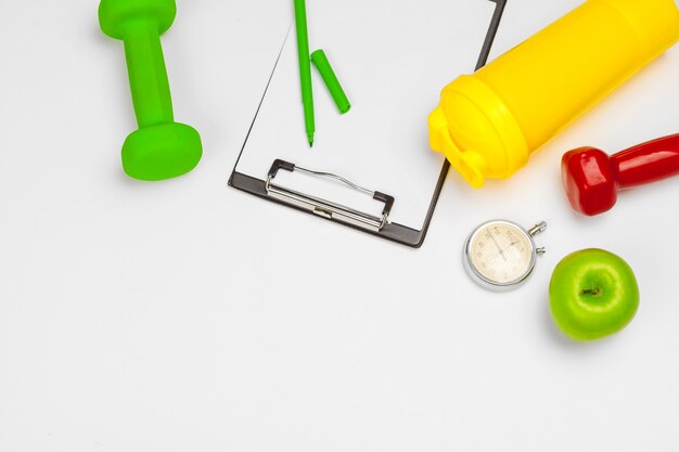 Portapapeles de maqueta con equipo de gimnasio con mancuernas en blanco