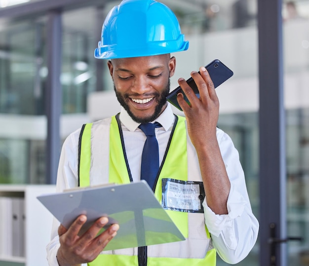 Portapapeles de trabajadores de la construcción y teléfono con un hombre en una llamada wifi en una oficina de ingeniería Contratista de arquitectura y lista de lectura de hombres afroamericanos durante una llamada telefónica para la industria