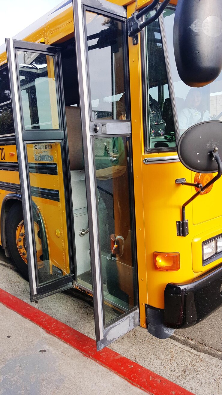 Foto portas abertas em ônibus amarelo na rua