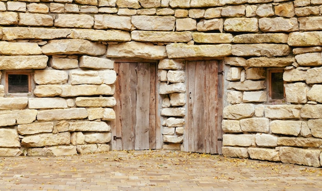 Portas antigas fechadas na parede de pedra áspera