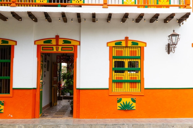 Foto portas de madeira coloridas em uma cidade na colômbia américa latina tons vermelhos e flores
