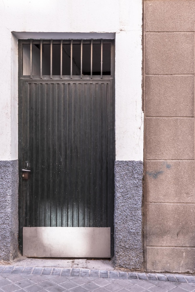 Foto portas metálicas pintadas de verde para acesso individual a instalações no piso térreo
