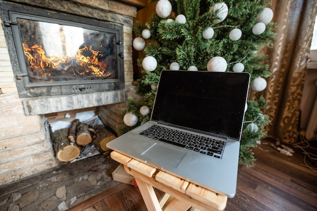 portátil y árbol de navidad en una antigua casa de madera