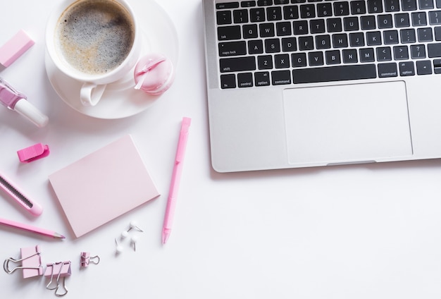 Foto portátil gris con papelería rosa