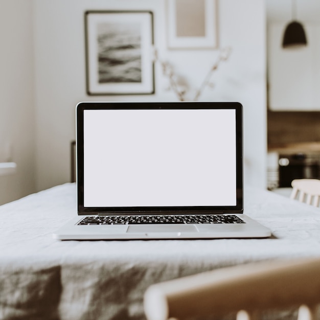 Portátil de pantalla en blanco. Espacio de trabajo de la mesa del escritorio de la oficina en casa