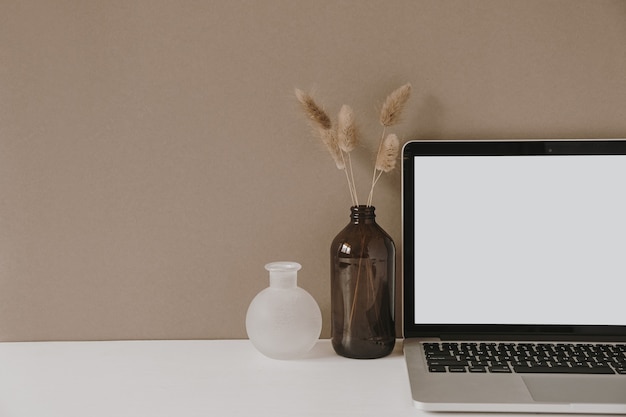 Portátil de pantalla en blanco. Espacio de trabajo de la mesa del escritorio de la oficina en casa