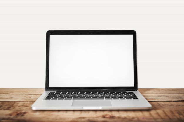 Foto portátil con una pantalla en blanco sobre una mesa de madera