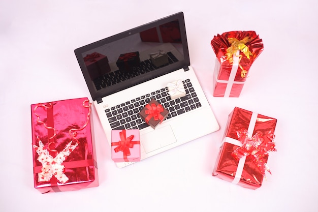 Foto portátil y regalos para la celebración de navidad y año nuevo aislado sobre fondo blanco.