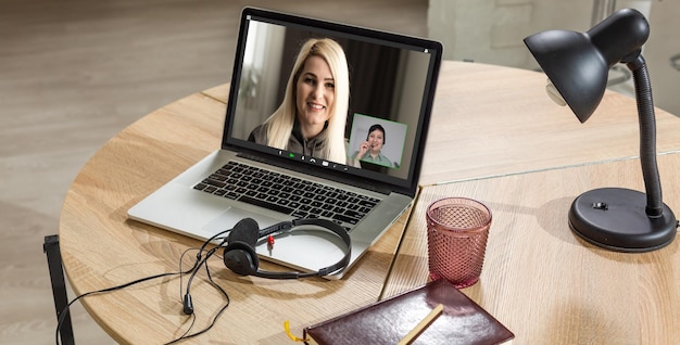 Foto portátil con soportes de videoconferencia sobre la mesa.