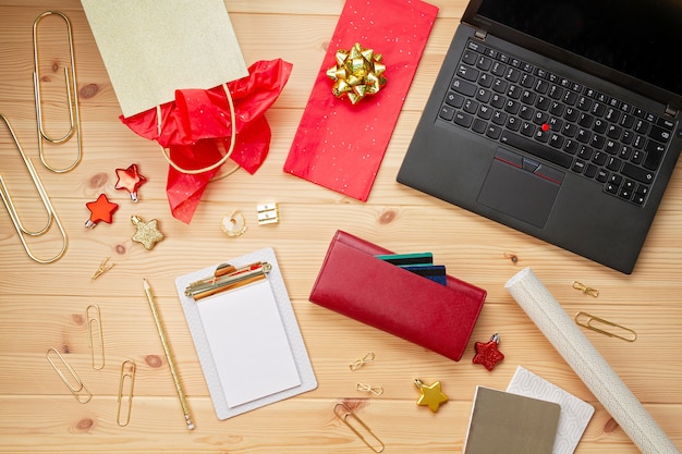 Portátil, tarjetas de crédito, monedero y decoración navideña. Compras navideñas en línea, compra de regalos