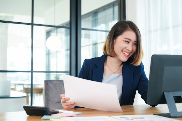 Portátil de trabajo de mujer asiática. Mujer de negocios ocupada trabajando en equipo portátil en la oficina.