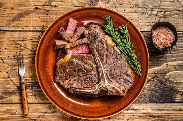 Porterhouse asado a la barbacoa o filete de carne de vacuno de hueso t en un plato rústico.