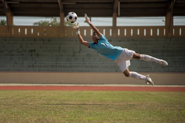 Portero de fútbol en acción en el estadio de fútbol