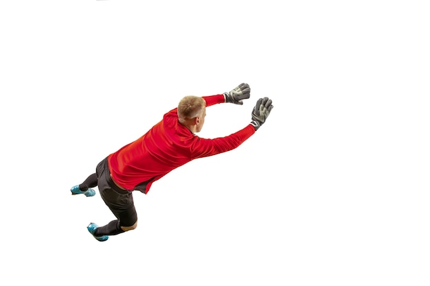 Portero de jugador de fútbol masculino atrapando la pelota en salto. Silueta de hombre en forma con balón aislado sobre fondo blanco de estudio