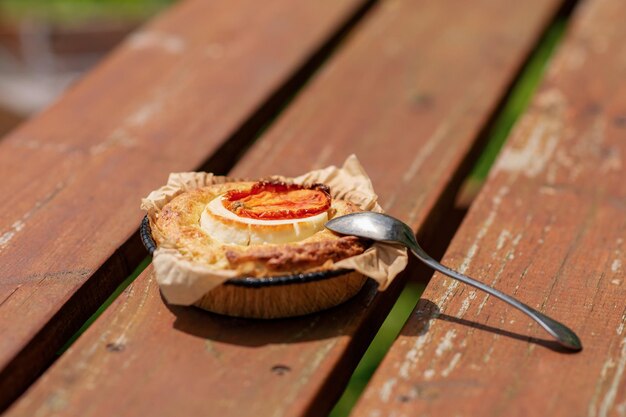 Portion Auflauf mit Käse und Tomaten auf einem Holzhintergrund