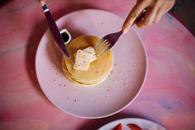 Portion Butterpfannkuchen auf runder rosa Platte. Konzept von Geschmack und Genuss. Hausgemachtes Essen.