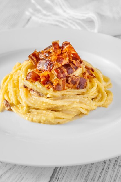 Portion Carbonara-Pasta, garniert mit gebratener Guanciale