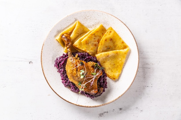 Portion Entenkeule mit Rotkohl und Kartoffelpuffer - Ansicht von oben.