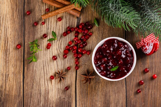 Foto portion hausgemachte cranberry-sauce cranberry-marmelade in weißer keramikschale kopierraum