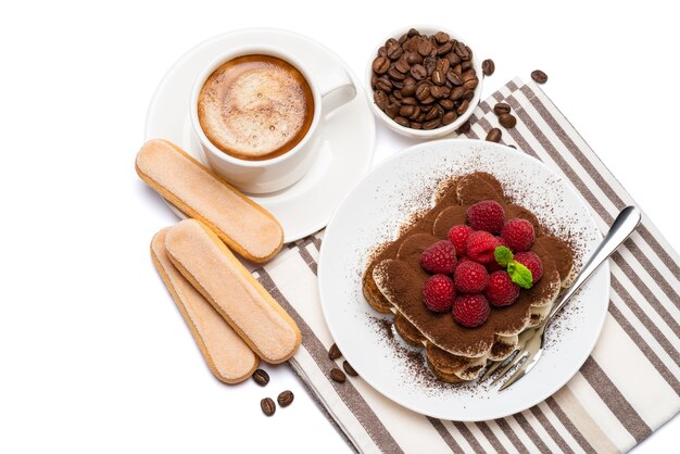 Portion klassisches Tiramisu-Dessert mit Himbeeren auf Keramikplatte