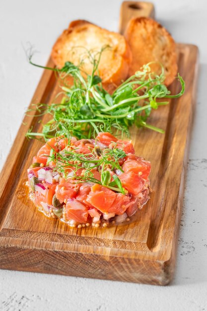 Portion Lachstatar mit Brot und Microgreen