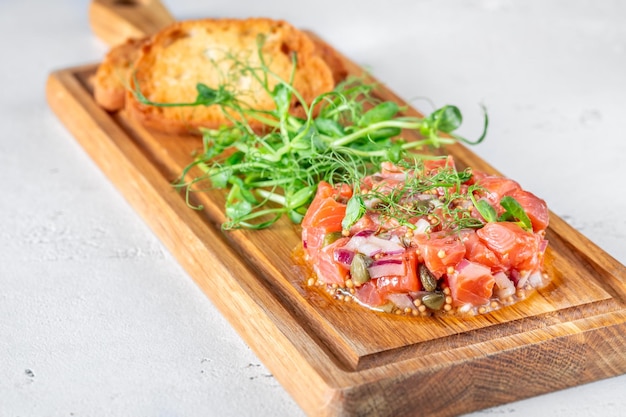 Portion Lachstatar mit Brot und Microgreen