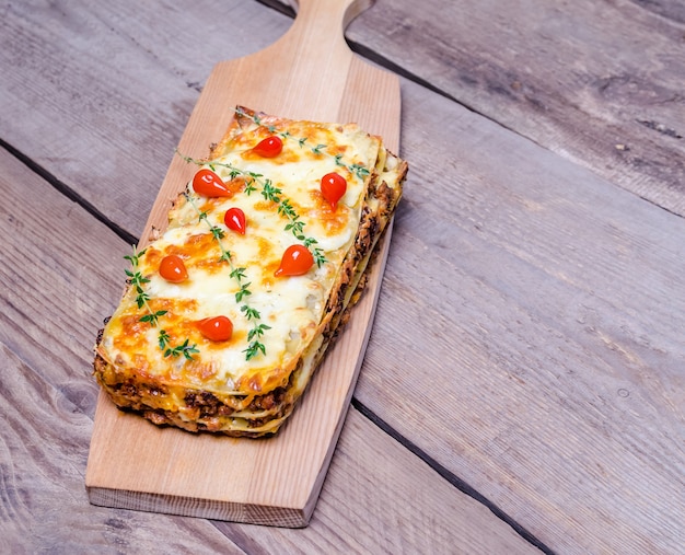 Portion Lasagne auf dem Holztisch