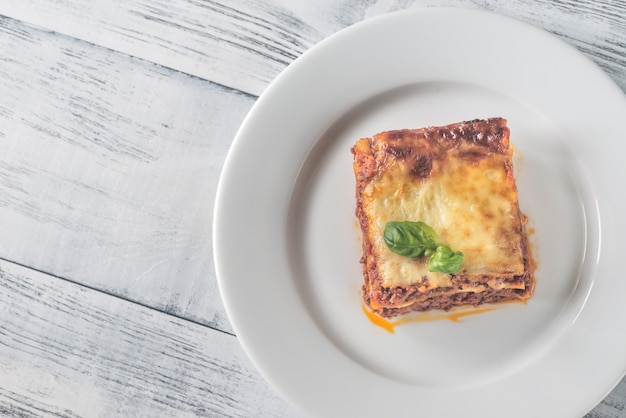 Portion Lasagne auf dem Holztisch