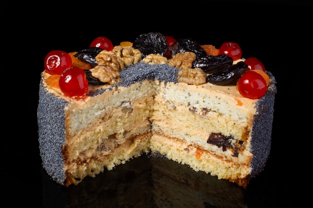 Portion Obstkuchen Walnuss mit Mohn bestreut auf schwarzem Hintergrund
