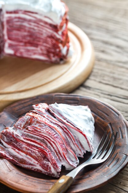 Portion roter Samtkreppkuchen auf dem Holztisch