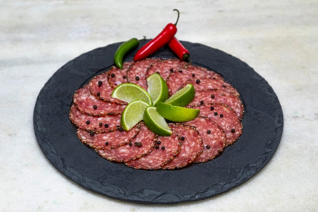 Portion Salami auf schwarzem Steinteller