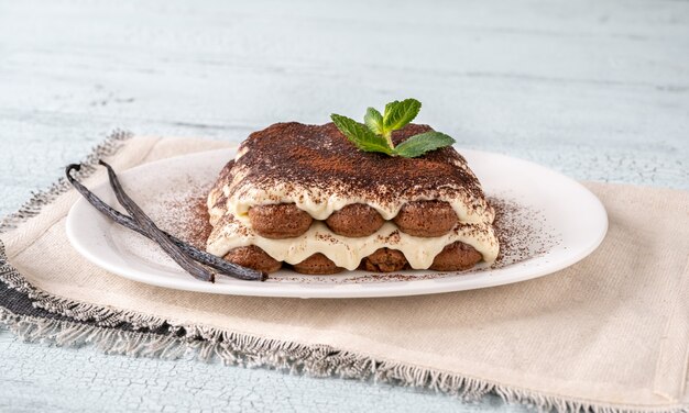 Portion Tiramisu auf weißem Servierteller