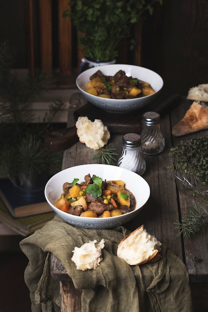 Portion traditioneller irischer Rindfleisch- und Guinness-Biereintopf mit Karotten, Kartoffeln und Erbsen