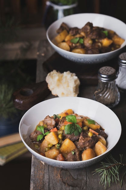 Portion traditioneller irischer Rindfleisch- und Guinness-Biereintopf mit Karotten, Kartoffeln und Erbsen