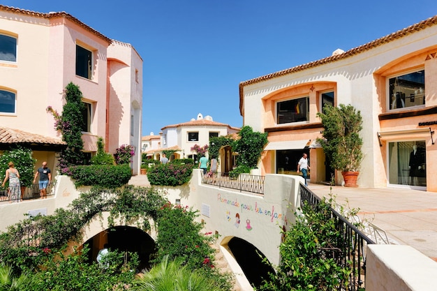 Foto porto cervo, italia - 11 de septiembre de 2017: paisaje urbano con arquitectura costera en la ciudad turística de lujo de porto cervo en la isla de cerdeña en italia en verano. gente en la ciudad sarda en cerdeña.