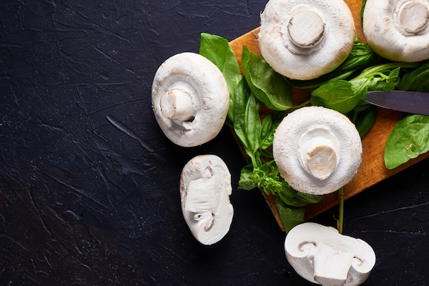 Portobello cogumelos brancos Grande champignon com manjericão em fundo escuro de pedra