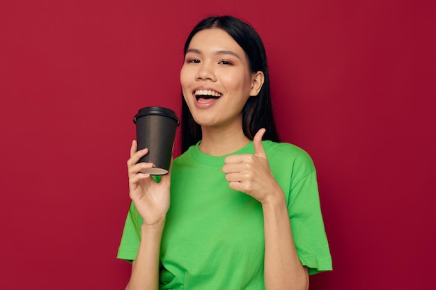 Porträt asiatische schöne junge Frau in einem grünen T-Shirt ein Glas Getränk Spaß isoliert Hintergrund unverändert