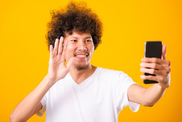 Porträt asiatischer gutaussehender Mann lockiges Haar, das selfie mit Smartphone nimmt