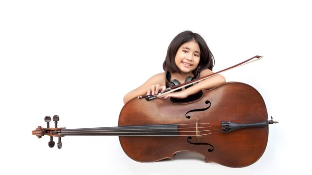 porträt asiatisches kind liebt klassische musik mit cello-saiteninstrument und kopfhörer auf weißem hintergrund isoliert. Musikvermittlungskonzept auf Bannergröße (Pfad angeben)